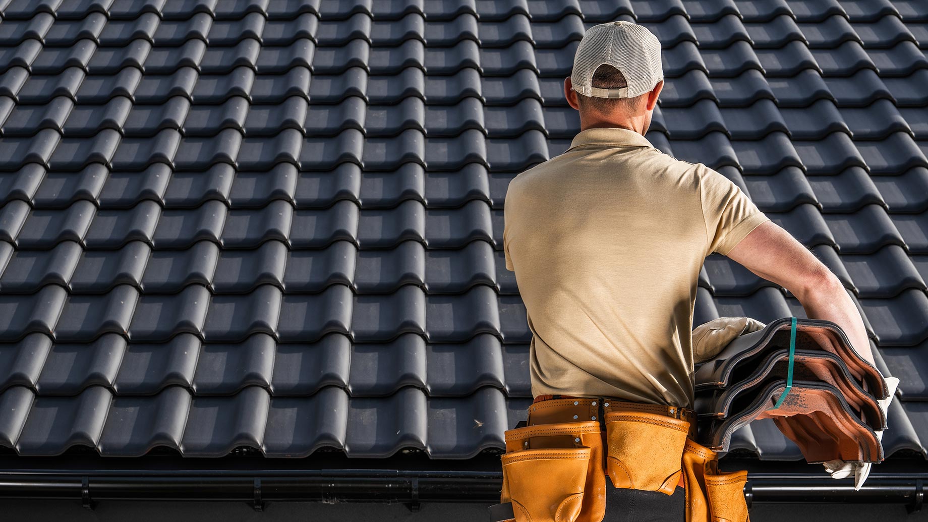 Roofing professional reviewing blueprint plans with homeowner